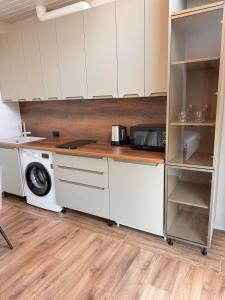 a kitchen with white cabinets and a washing machine at Yu-home 2 in Mukacheve