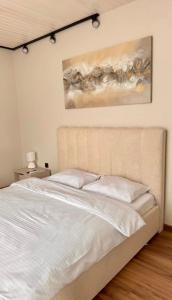 a bed in a bedroom with a painting on the wall at Yu-home 2 in Mukacheve