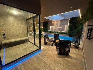 a living room with a swimming pool and a table and chairs at Motel DUBAI BH in Belo Horizonte
