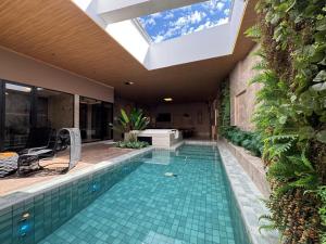 a swimming pool with a skylight in a house at Motel DUBAI BH in Belo Horizonte