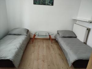 een kamer met 2 bedden en een glazen tafel bij Iriska Home in Warschau
