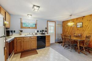 eine Küche mit Holzschränken, einem Tisch und einem Esszimmer in der Unterkunft Moose’in Around in Sweden