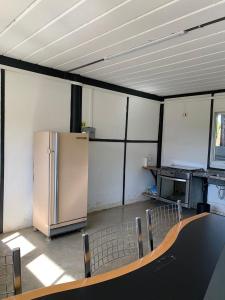a room with a refrigerator and a table and chairs at Dona Floripes Flats in Campinas