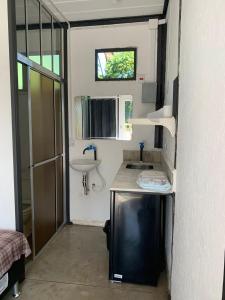a small bathroom with a sink and a mirror at Dona Floripes Flats in Campinas