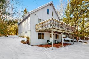 ein weißes Haus mit einer Terrasse im Schnee in der Unterkunft Moose’in Around in Sweden