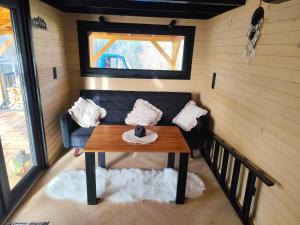 a living room with a couch and a table at Tiny House Barujec in Brenna