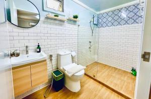 ein Badezimmer mit Toilette, Waschbecken und Spiegel in der Unterkunft Secret Palm in Ko Phangan