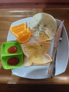 a plate of breakfast food with eggs toast and fruit at Tama View in Tuktuk Siadong