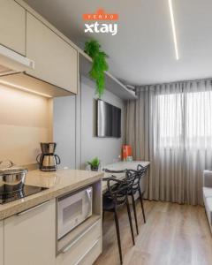 a kitchen with a table and chairs in a room at Easy Life Campos PUC by Xtay - Hospede-se próximo ao Viasoft Experience e Estádio Durival in Curitiba