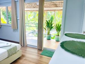 a bedroom with two beds and a large window at Secret Palm in Ko Phangan