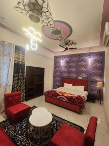 a bedroom with a red bed and a purple wall at Dks villa Homestay in Agra