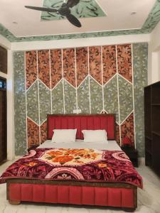 a bedroom with a red bed and a wall at Dks villa Homestay in Agra