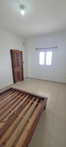 a bedroom with a wooden bed in a room at Villa Alicia Vavindrano in Fort Dauphin