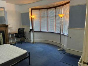 een kamer met een bed, een raam en een bureau bij Lennox Road Small Rooms Inn in Bletchley