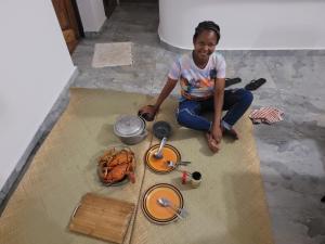 a woman sitting on the floor next to some food at Villa Alicia Vavindrano in Fort Dauphin