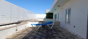 a blue chair sitting on the patio of a house at Interlace penthouse with swimming pool in Il-Ħamrija +44 photos