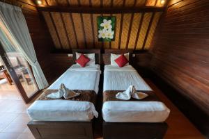 two beds in a room with shoes on them at Bataran Garden Cottage in Nusa Penida +52 photos