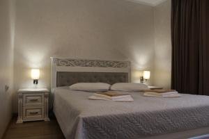 ein Schlafzimmer mit einem Bett, auf dem zwei Handtücher liegen in der Unterkunft HOTEL Баймонт in Synjak