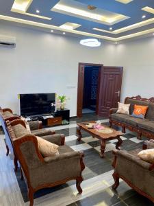 a living room with couches and a flat screen tv at Résidence Prestige KGV Appt 201 in Douala