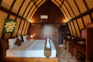 a bedroom with a large bed in a room at Bataran Garden Cottage in Nusa Penida