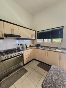 een keuken met witte kasten en een kookplaat oven bij Maja Hzari in Densainagar +30 foto's