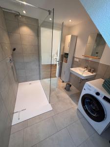 a bathroom with a shower and a washing machine at Style Loft mit Ausblick in Elzach in Elzach +25 photos