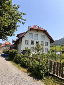 een wit huis met een hek ervoor bij Style Loft mit Ausblick in Elzach in Elzach