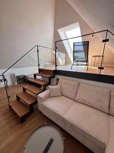 een woonkamer met een bank en een trap bij Style Loft mit Ausblick in Elzach in Elzach +17 foto's