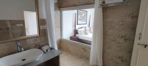 un bagno con un lavandino, uno specchio e una finestra di The Devi Lake Stay Udaipur a Udaipur