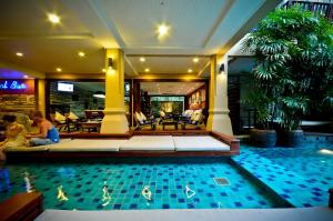 a hotel room with a swimming pool and a pool table at Burasari Phuket Resort & Spa - SHA Extra Plus in Patong Beach