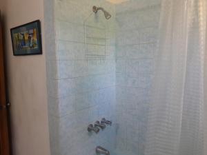 a bathroom with a shower with a shower curtain at Coco Gardens in Negril +21 photos