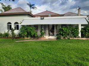 a house with a green lawn in front of it at Coco Gardens in Negril
