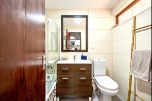 une salle de bains avec toilettes, lavabo et miroir dans l'établissement Casa do Mar, à Sesimbra 9 autres photos