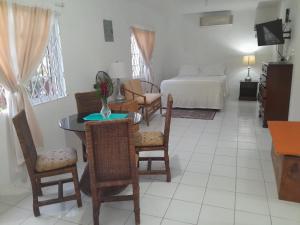 a living room with a table and chairs and a bed at Coco Gardens in Negril