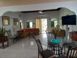 a living room with a glass table and chairs at Coco Gardens in Negril
