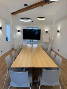 a conference room with a large wooden table and chairs at La Champagnère - Domaine avec piscine - Séminaire - 15 personnes in Basse-Goulaine