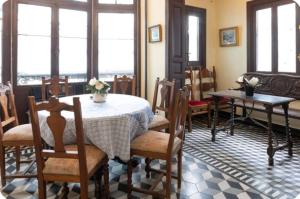 a dining room with a table and chairs and windows at Palacio de la Monstrua in Avilés