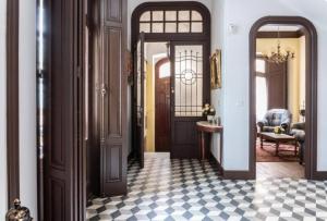 a hallway with doors and a checkered floor at Palacio de la Monstrua in Avilés