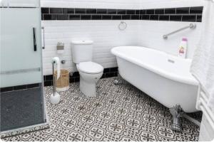 a bathroom with a tub and a toilet and a sink at Palacio de la Monstrua in Avilés