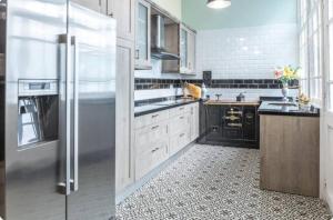 a kitchen with white appliances and a black refrigerator at Palacio de la Monstrua in Avilés