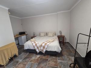 a bedroom with a bed and a tiled floor at House 205 in Vanderbijlpark