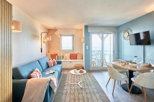 a living room with a blue couch and a table at Résidence Pierre & Vacances Les Tamaris in Trouville-sur-Mer +39 photos