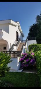 een wit huis met trappen en paarse bloemen bij Resort Comfort Long Beach in Ulcinj