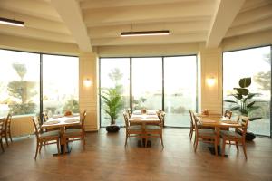 a restaurant with tables and chairs and large windows at Lina Garden Otel in Bingol