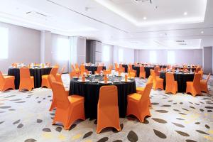 a conference room with tables and chairs in a hall at J Hotel - Bandara Soekarno Hatta in Tangerang