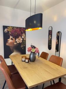 Una mesa de comedor con un jarrón de flores encima. en Casa-Mia City, en Kempten