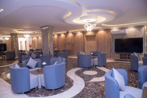 沙鲁拉بن سنكر لشقق المخدومة的一个大房间里摆放着蓝色椅子和一台平板电视。