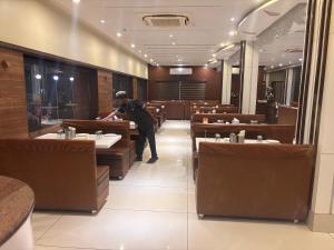 een man staat in een eetkamer bij Hotel Tulsi Icon in Jāmb