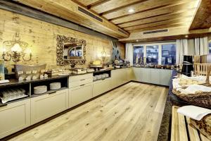 a large kitchen with wooden walls and wooden floors at Hotel Unterhof in Filzmoos
