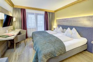 a hotel room with a bed and a desk at Hotel Unterhof in Filzmoos +48 photos